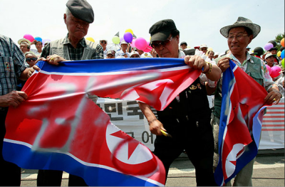 South Korean activists rip up North Korean flags to mark the 60th anniversary of the Korean war
