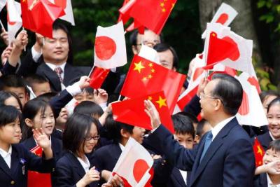 Chinese Premier Wen Jiabao waves to children during a welcoming ceremony at Japanese Prime Minister Yukio Hatoyama’s official residence in Tokyo in May this year