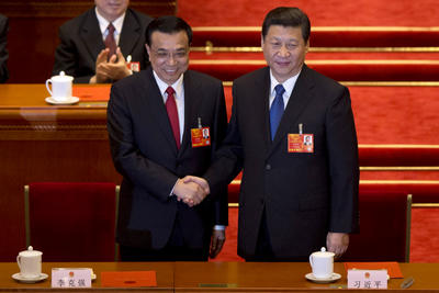 Newly-named Chinese Premier Li Keqiang, front left, poses with newly-named Chinese President Xi Jinping, while delegates clap when Li was announced to be the nation's new premier during a plenary session of the National People's Congress held in Beijing's Great Hall of the People Friday, March 15, 2013. (PHOTO: AAP)