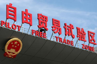 A Chinese worker installs signs of the China (Shanghai) Pilot Free Trade Zone on a gate of the Shanghai Waigaoqiao Free Trade Zone, part of the pilot zone, in Pudong, Shanghai, China, 26 September 2013. (Photo: AAP)