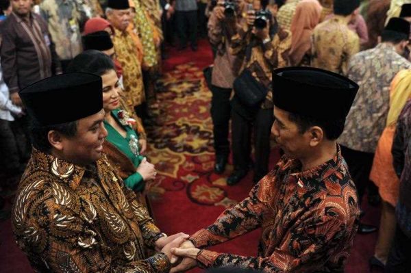 New President Joko Widodo shakes hands with Minister of trade Rahmat Gobel during the Working Cabinet's official inauguration at the presidential palace in Jakarta on October 27, 2014. (Photo: AAP)