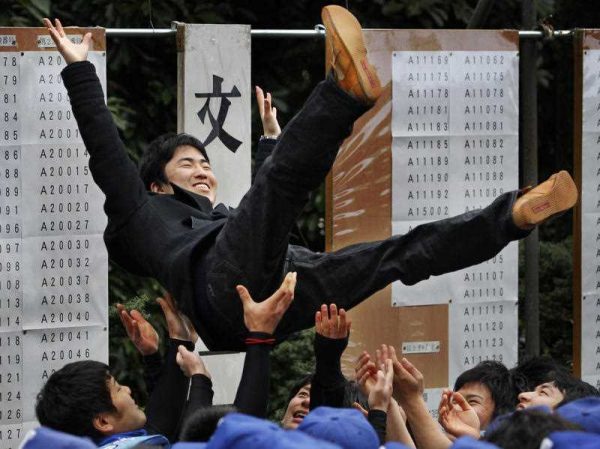 A student who successfully passed the entrance examination for the University of Tokyo is congratulated by his peers as the results of Japan's most prestigious university exam is announced at its campus in Tokyo. (Photo: AAP).