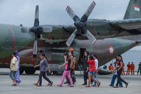 Undocumented Indonesian workers walk on the tarmac towards an Indonesian military C-130 aircraft at Subang Air Force base in Subang, outside Kuala Lumpur, on 23 December 2014. (Photo: AAP)