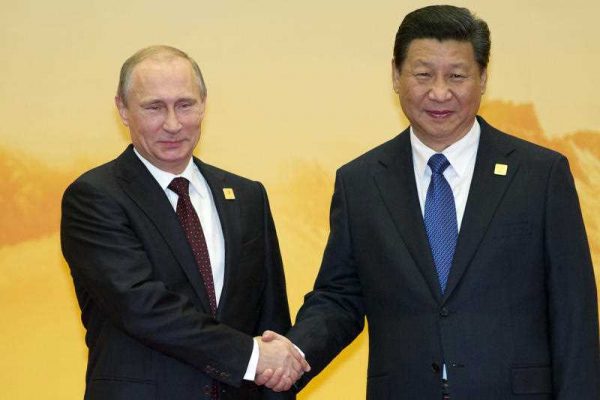 Russian President Vladimir Putin, left, shakes hands with Chinese President Xi Jinping during a welcome ceremony for the Asia-Pacific Economic Cooperation (APEC) Economic Leaders Meeting held at the International Convention Center in Yanqi Lake, Beijing, on Tuesday, Nov 11, 2014. (Photo: AAP)