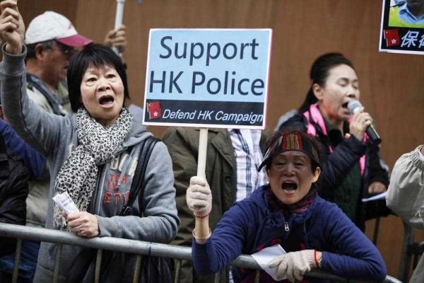 Pro-government protesters demonstrate in support of police as another group took part in a protest march against police brutality during pro-democracy protests in Hong Kong on 7 December 2014. (Photo: AAP)