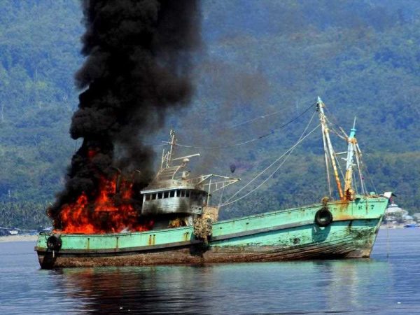 One of two foreign fishing boats suspected of conducting illegal fishing activities is blown up by the Indonesian navy in Ambon bay, Indonesia, 21 December 2014. (Photo: AAP).