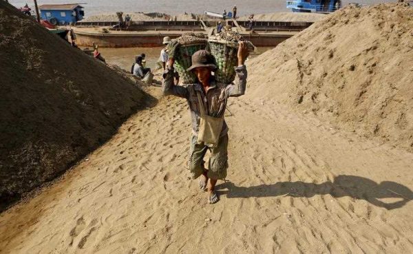 Myanmar worker carries two baskets loaded with gravel on his shoulders as he unloads a boat to a jetty of Yangon River, Yangon, Myanmar, 27 January 2015. (Photo:AAP).