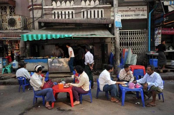 Customers sitting with drinks at a traditional roadside coffee shop in downtown Yangon, Myanmar, 28 January 2015. (Photo: AAP).