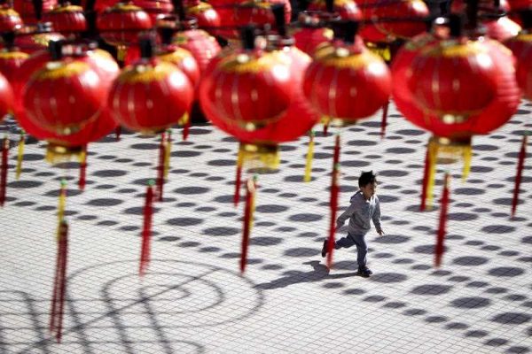 A boy runs at a temple casted with shadows of traditional Chinese lantern decorations ahead of the Chinese Lunar New Year in Kuala Lumpur, Malaysia, on Tuesday, 17 Feb 2015. (Photo: AAP)