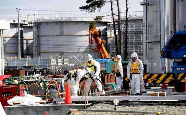 Workers wearing protective suits construct tanks to store contaminated water at the Fukushima No. 1 nuclear power plant. Sensors of the Tokyo Electric Power Company (TEPCO) have detected a new leak of highly radioactive water, 23 February 2015. The firm has continued to decommission the crippled plant. (Photo: AAP).