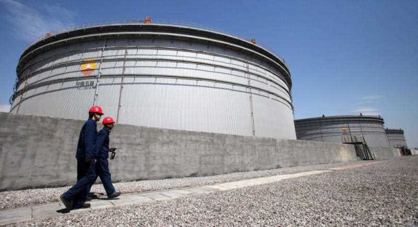Chinese inspectors patrol past crude oil tanks at the Dagang commercial oil reserve base of CNPC (China National Petroleum Corporation), parent company of PetroChina, in Tianjin, China, 5 April 2012. (Photo: AAP)