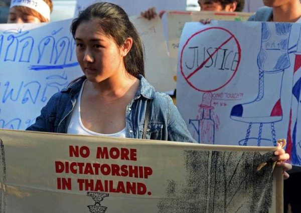 Thai students display placards as they demonstrate in front of the military court in Bangkok on 16 March 2015. (Photo: AAP)