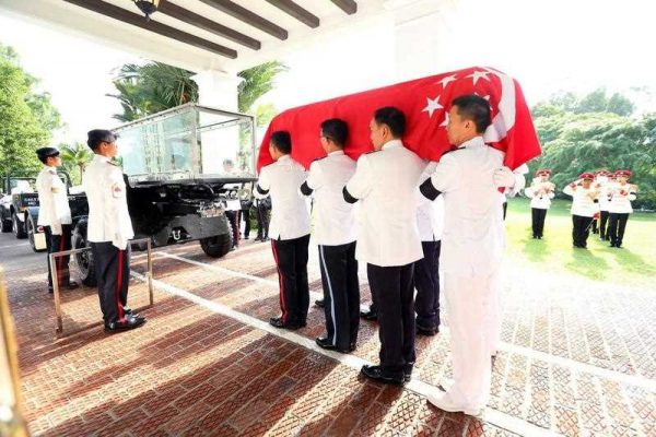 Officers lift the coffin of late Lee Kuan Yew prior to his procession to Parliament House, at Istana Palace, Singapore, 25 March 2015. (Photo: AAP)