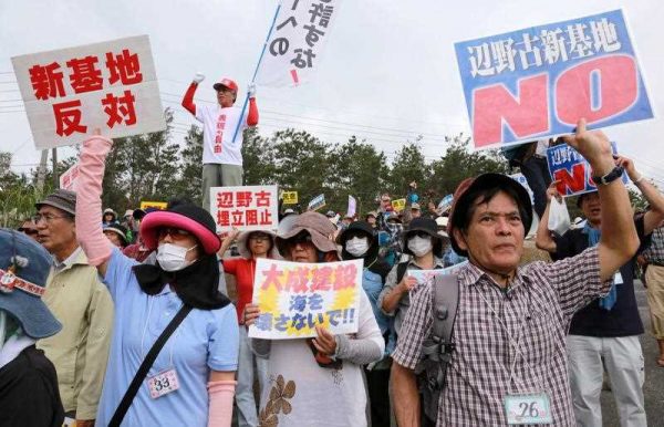 Protesters gather holding placards reading 'NO to the new base in Henoko!' during a demonstration against the construction of a new US military base in an environmentally sensitive part of the island in Nago city, Okinawa island on 28 April 2015. (Photo: AAP)