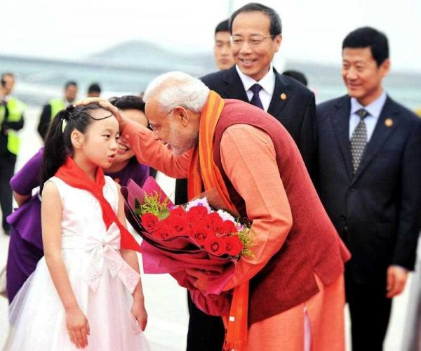 India's Prime Minister Narendra Modi receives a floral bouquet from a young Chinese child on his arrival at Xi’an Xiangyang International Airport in Xi’an, 14 May 2015. (Photo: AAP)