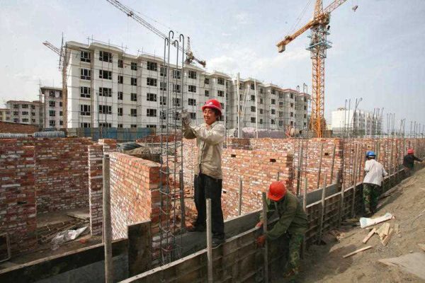Chinese workers construct residential buildings of a government-funded housing project in Tiemenguan city, northwest China's Xinjiang Uygur Autonomous Region, 2 May 2015. (Photo: AAP).