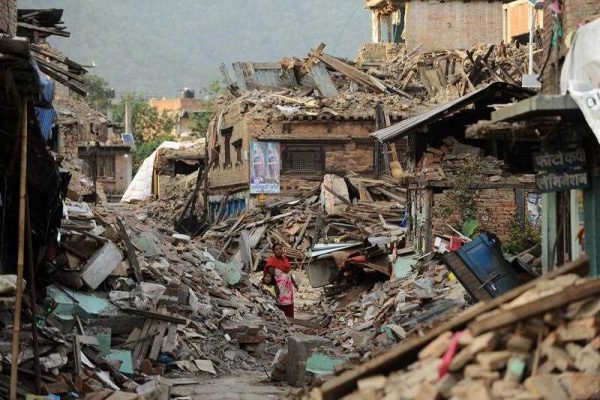 A Nepalese woman walks past damaged houses following an earthquake in Kathmandu on 26 May 2015. (Photo: AAP)