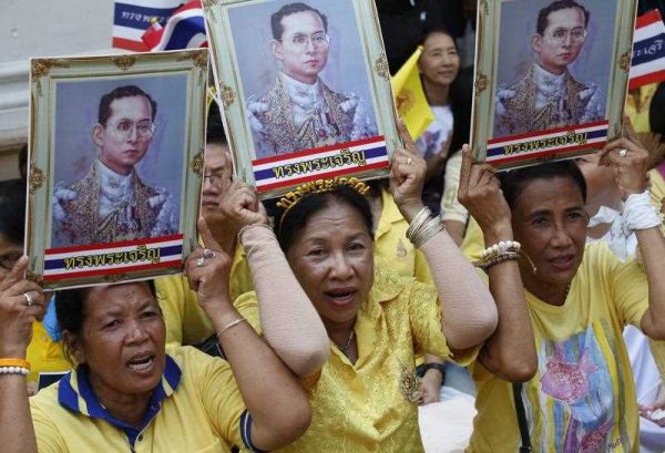 Thai well-wishers hold up photographs of King Bhumibol Adulyadej as they wait for his departure at the Siriraj Hospital in Bangkok, Thailand, 10 May 2015. (Photo: AAP).