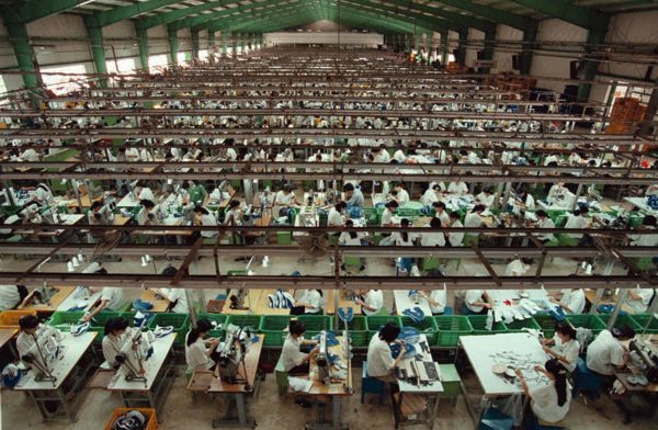 A thousand workers are shown stitching uppers for Nike shoes, July 26, 1997, at the Korean-owned Tae Kwang Vina factory, in Ho Chi Minh City, Vietnam. One floor below 2000 workers are doing the same. The Factory employs 8,750 workers. For the past three years, pressure has typified the Asian factories that churn out Nike shoes and clothes, which has led to abuse in some cases. Nike company officials say the Nike-aligned factories offer respectable wages, where working conditions have improved and abuses are relatively few. (Photo: AAP)