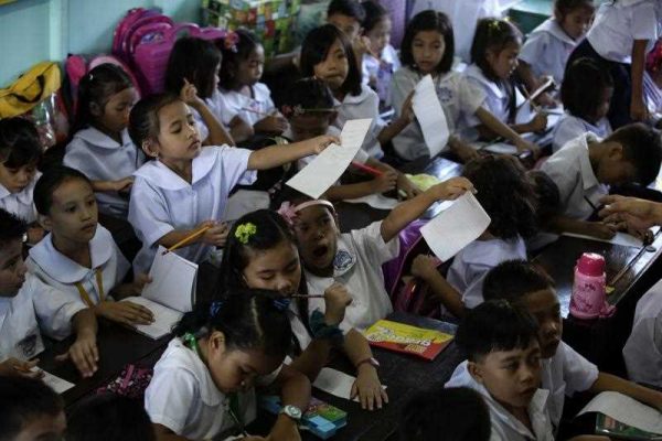 Filipino pupils return their papers in a classroom during the first day of school at the President Corazon Aquino Elementary School in Quezon city, east suburban Manila, Philippines, 02 June 2014.