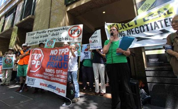 Protestors stand at a rally outside the Sheraton Hotel in Sydney as global trade ministers meet at the venue to discuss the Trans-Pacific Partnership (TPP) free-trade agreement on 25 October 2014. (Photo: AAP)