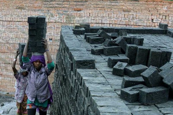 Indian labourers work at a brick manufacturing unit on the outskirts of Hyderabad on 2 March 2015. India's factory output in February grew at its slowest pace in five months as business demands remained dim. (Photo: AAP)