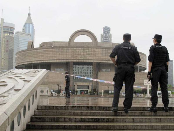 Chinese police stand next to a roped-off plaza near the Shanghai Museum in Shanghai, 27 June, 2015. (Photo: AAP)