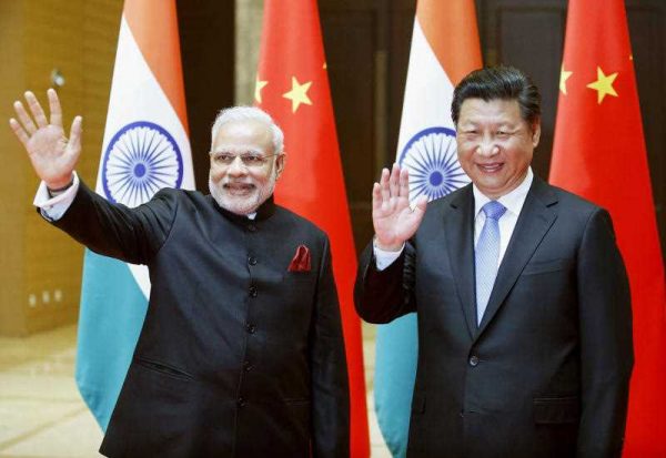 India's Prime Minister Narendra Modi (L) and China's President Xi Jinping wave to the press before their meeting in Xian, the capital of the Chinese Shaanxi Province, on 14 May 2015. (Photo: AAP)