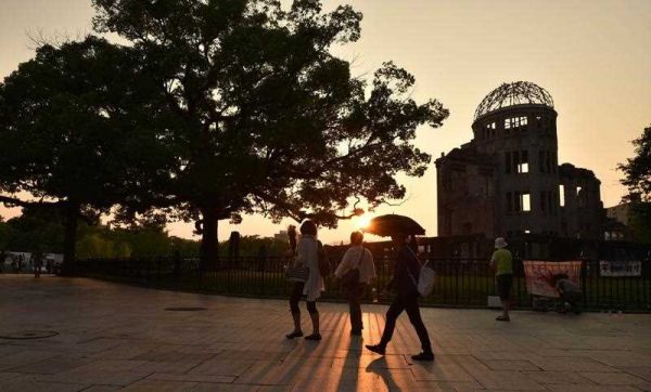 People walk past the Atomic Bomb Dome beside the Peace Memorial Park at sunset in Hiroshima on 5 August 2015. Japanese Prime Minister is scheduled to make a statement commemorating WWII on 14 August. (Photo: AAP)