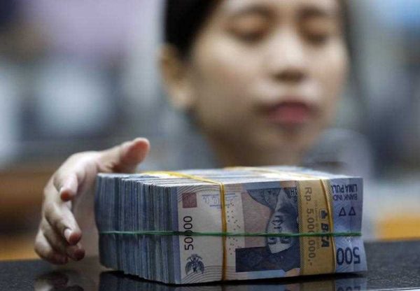 An Indonesian employee prepares rupiah banknotes at a money changer in Jakarta, Indonesia, 25 August 2015. (Photo: AAP)