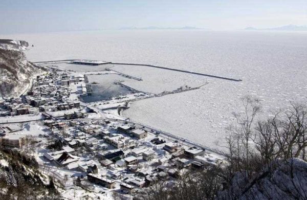 ausu, a fishing port on northern Japanese island of Hokkaido, is covered in ice, 15 February 2011. In the rear is Kunashir Island, on the Russian- controlled Northern Territories or Kuril Islands. (Photo: AAP)