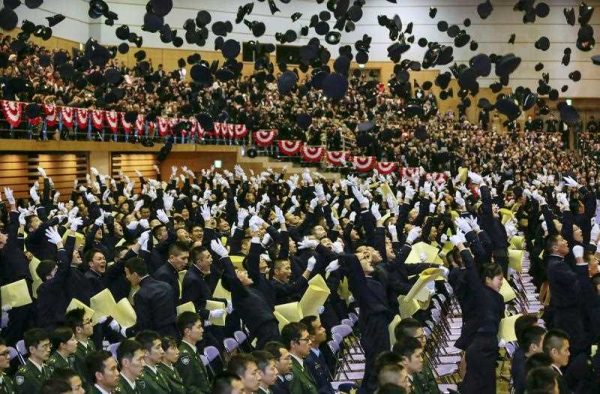 Graduates of the National Academy toss up their caps into the air to celebrate their graduation during the graduation ceremony at the National Defense Academy in Yokosuka, south of Tokyo, Japan, 22 March 2015 (Photo: AAP)