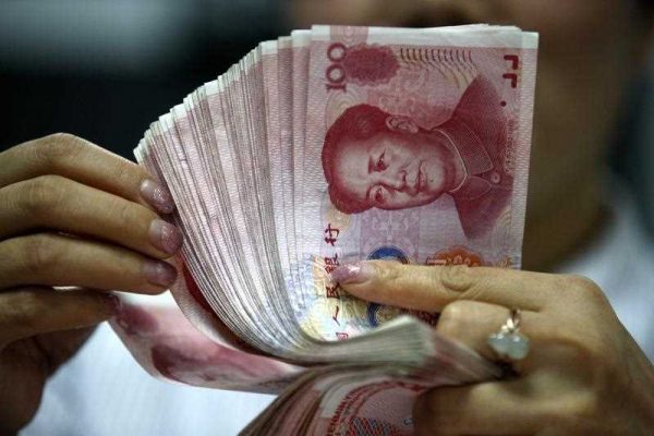 A Chinese clerk counts RMB (renminbi) yuan banknotes at a bank in Huaibei city, east China's Anhui province, 11 August 2015. China's sudden decision last month to devalue its currency riled neighbors and fueled investors' fears about a sharp slowdown in the world's No. 2 economy. (Photo: AAP)