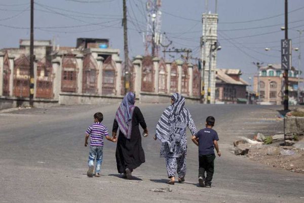 Kashmiri Muslim women walk with children on a deserted street during a curfew in Kashmir, 12 September 2015. The most recent data released on religion in India was from 2011. (Photo: AAP)
