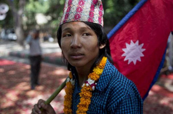 A boy carries the national flag of Nepal during a protest in New Delhi, India, Tuesday, Sept. 22, 2015 (Photo: AAP)