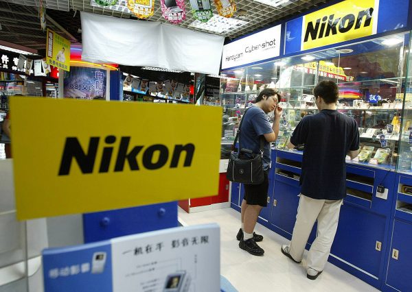 A man shops for Japanese-brand Nikon digital cameras, 09 July 2003, at a tech-mall in Beijing. China's import volume is expected to jump between 12 and 15 percent this year, outgrowing exports, according the Ministry of Commerce. Digital cameras, steel and cars were among the commodities registering higher growth since early 2002. (Photo: AFP)