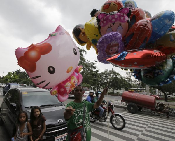A vender sells Hello Kitty balloon in Manila, Philippines (Photo: AAP).