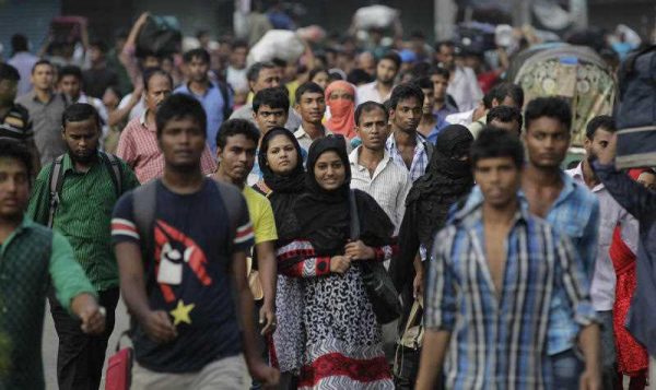 Bangladeshi people walk on a street early morning in Dhaka, Bangladesh, Thursday, 1 October, 2015. The World Bank has recently reassessed Bangladesh as a middle-income country. (Photo: AAP)