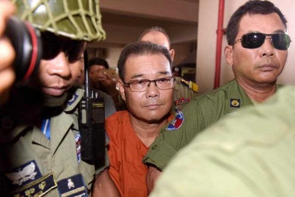 Cambodian senator Hong Sok Hour (C), who belongs to a CNRP-affliated party, is escorted by police at Phnom Penh municipal court on October 7, 2015, in a case in which he could be jailed for 17 years after a court charged him on August 16 over the posting of a disputed document on social media about the border with Vietnam. (Photo: AAP)