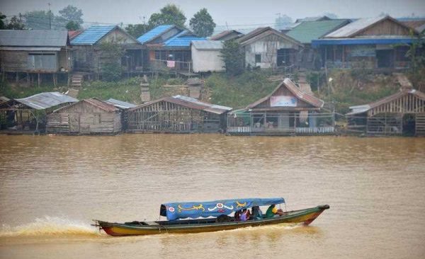 Local residents travel by boat along the Kahayan river in Palangkaraya, in Central Kalimantan, on 29 October, 2015 as residents enjoy clearer skies after many days of choking haze. Rain and favourable winds have brought clear skies to vast areas of Southeast Asia on 29 October stricken for weeks by hazardous smoke from Indonesian fires, with officials expressing hope that the crisis could end soon. (Photo: AAP)