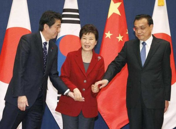 South Korean President Park Geun Hye clasps hands with Chinese Premier Li Keqiang and Japanese Prime Minister Shinzo Abe before their trilateral summit at the presidential Blue House in Seoul on 1 November 2015. (Photo: AAP)