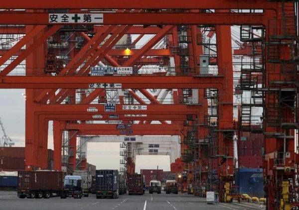 Containers are unloaded from a cargo vessel as truck make a long queue at Aomi International Container terminal in Tokyo, Japan, 16 November 2015. (Photo: AAP)