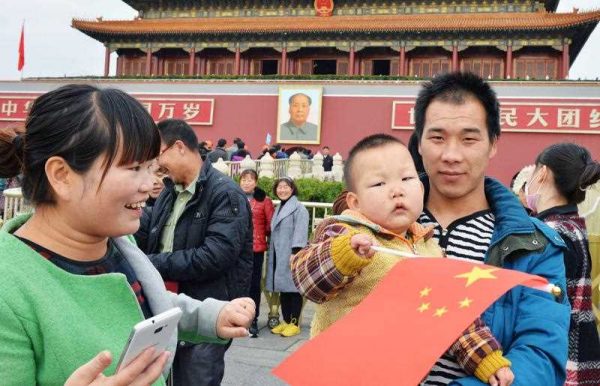 A young couple with a child visit Tiananmen Gate in Beijing on Nov. 17, 2015. (Photo: AAP)
