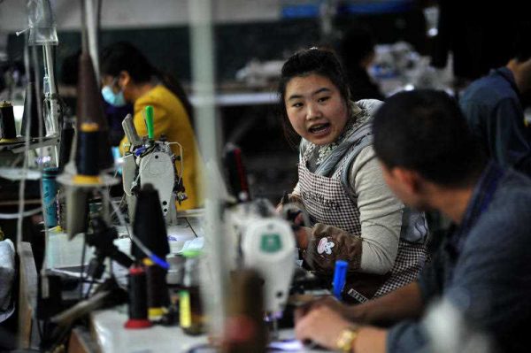 A couple works in a small clothes factory in Tudi Village, which is known as 'Taobao Village' due to its fast developing rural electronic commerce, in Pixian County in Chengdu in southwest China's Sichuan province on 7 November 2015. (Photo: AAP)