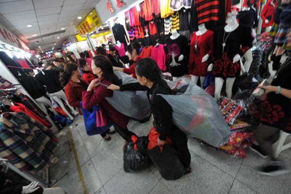 People deliver clothes at the Dacheng Clothes Market in Tudi Village. (Photo: AAP)