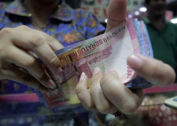 n Indonesian vendor counts Rupiah notes at a market in Jakarta, Indonesia, 10 December 2015. (Photo: AAP)