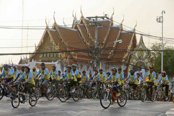 A pack of cyclists ride their bicycles past the Marble Temple during the Bike for Dad, mass bicycle ride campaign held to celebrate the 88th birthday of Thai King Bhumibol Adulyadej in Bangkok, Thailand, 11 December 2015. (Photo AAP).