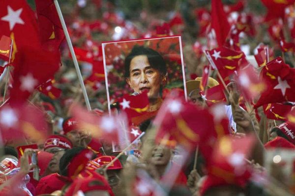 Supporters of Myanmar opposition leader Aung San Suu Kyi hold posters bearing her image as they listen as she speaks during a campaign rally for the National League for Democracy in Yangon on 1 November 2015. (Photo: AAP)