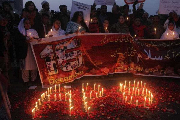 Candles form the initials of the Army Public School as people attend a ceremony in connection with the first anniversary of a school attack in Peshawar on December 16 2015 in Lahore, Pakistan. (Photo: AAP).