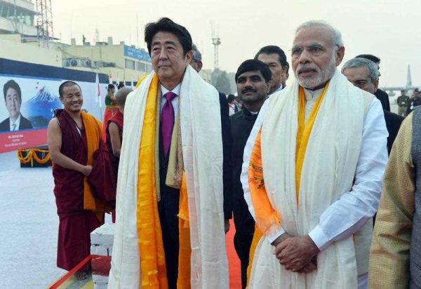 A handout picture made available by the Indian Press Information Bureau (PIB) shows Japanese Prime Minister, Shinzo Abe (C), with the Indian Prime Minister, Narendra Modi (R), receiving a traditional welcome on their arrival to attend the traditional Ganga 'aarti' or worship of the holy Ganges river in Varanasi, India, 12 December 2015. (Photo: AAP)
